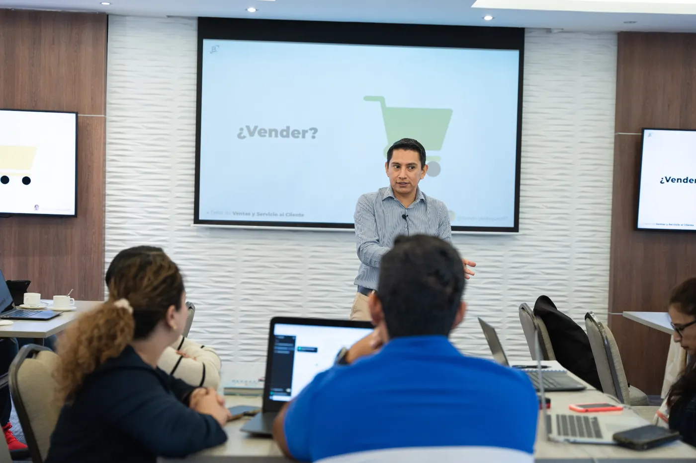 Simón Velásquez facilitando una capacitación presencial frente a un equipo corporativo