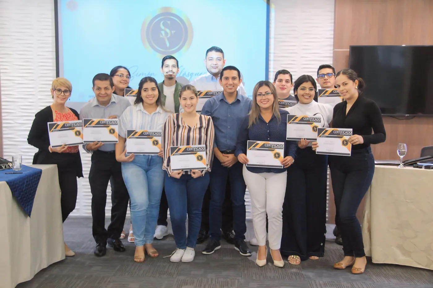 Grupo de participantes junto a Simón Velásquez al cierre de una capacitación con certificados