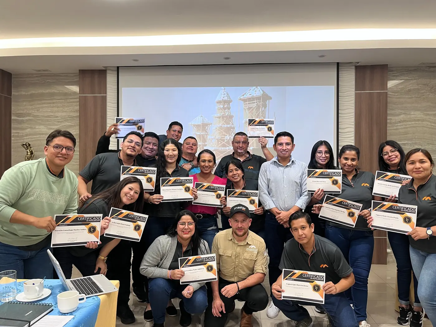 Grupo de participantes mostrando certificados al finalizar una capacitación